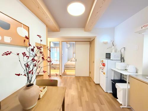 a kitchen with a table with a vase on it at Tsuruhashi 1F 9 min walk &3BR Apt for 6&Near Enba Natural Onsen&JR Direct to Namba, Nara & USJ in Osaka