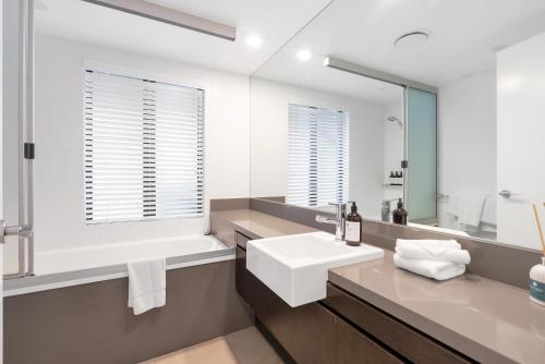un bagno con un lavandino bianco e uno specchio di Lagoon Sanctuary - Resort Living by Four Mile Beach a Craiglie