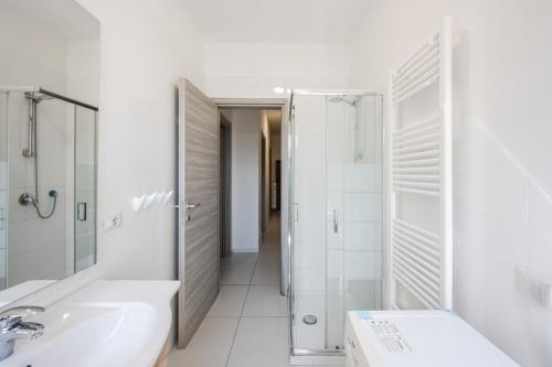 a white bathroom with a shower and a sink at Rubiera Residence - H24 in Zimella