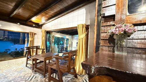 - une salle à manger avec une table, des chaises et un vase fleuri dans l'établissement Kawarin Saiyai Cottage and Lake, à Ban Pracham Mai Bon