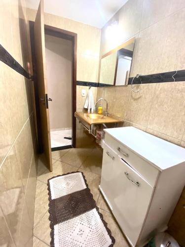 ein Badezimmer mit Waschbecken und Spiegel in der Unterkunft Casa Aconchegante no Coração de Arraial - Com Churrasqueira Privativa in Arraial do Cabo