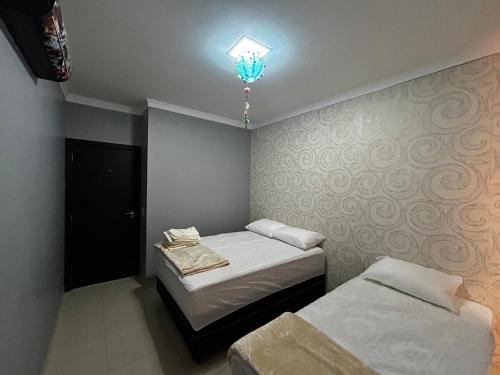 een slaapkamer met 2 bedden en een kroonluchter bij Casa aconchegante em local Estratégico in Foz do Iguaçu