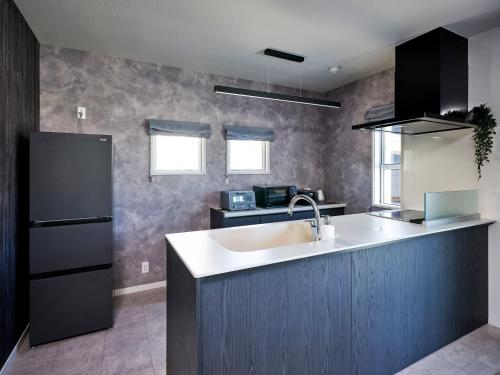 a kitchen with a sink and a refrigerator at VOGUE C, a private inn with a panoramic view of th - Vacation STAY 14693v in Isumi