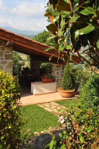 a patio with a wooden pergola in a yard at Albergo Ristorante La Torricella in Poppi