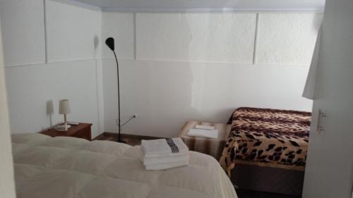 a white room with two beds and a lamp at Cazartes puma in Treinta y Tres