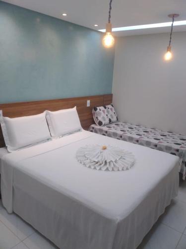 ein Schlafzimmer mit einem großen weißen Bett und einer Couch in der Unterkunft Mandacaru pousada in Maceió