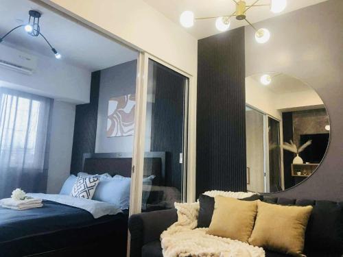 a living room with a couch and a mirror at Acqua Private Residences Livingstone Tower in Sampong