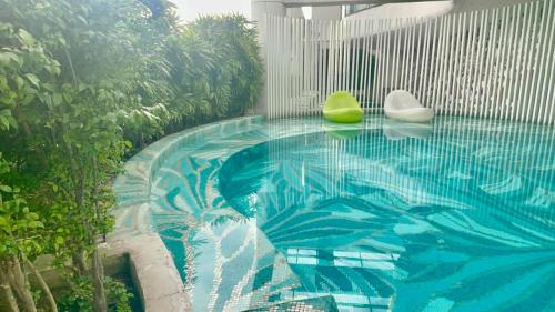 a swimming pool with two chairs and a swimming pool at Acqua Private Residences Livingstone Tower in Sampong