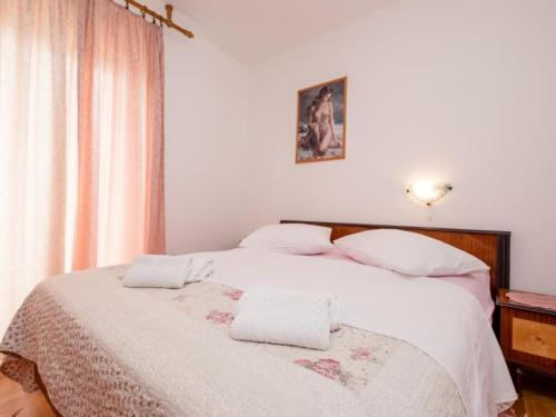 a bedroom with a white bed with two towels on it at Apartments Scerbe Gordana & Miljenko Rab - Two Bedroom Apartment with Terrace 1 in Otok Rab