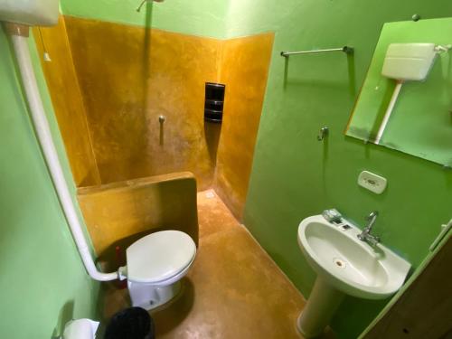 a bathroom with a white toilet and a sink at Pousada do Caminho Trancoso in Porto Seguro