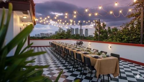 una mesa larga con sillas y luces en un patio en MiraNamin Nest SAMPAGUITA Suite - Balconies, Garden View, Pet Friendly with a Fee, en Manila