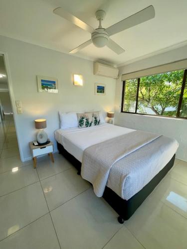 a bedroom with a large bed and a window at Myuna Holiday Apartments in Noosa Heads