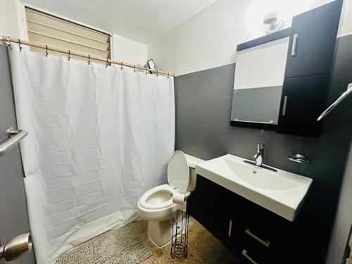 Un baño con un inodoro blanco y un lavabo. en 3 Bedroom Home Best Price Bayamon by Rentalspr, en Bayamón