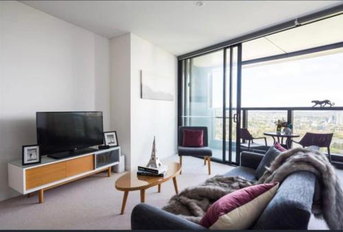 a living room with a couch and a tv at L19 Spacious Apt, Wi-Fi, Parking by Stylish Stays in Brisbane