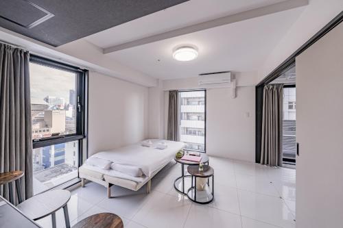 a white room with a bed and some windows at 大阪難波リバーサイドガーデンホテルOsaka Namba River Side Garden Hotel in Osaka