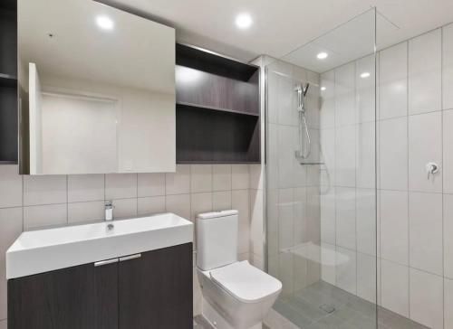a bathroom with a toilet and a sink and a shower at LvL29 Rooftop Pool Carpark Netflix by Stylish Stays in Brisbane