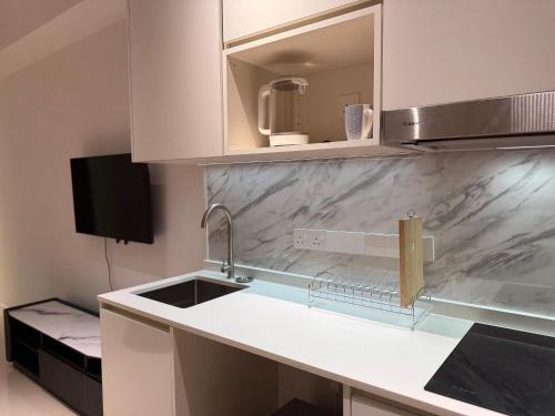 een keuken met een spoelbak en een aanrechtblad bij Bay Suite at Kota Kinabalu - 8Avenue in Kota Kinabalu