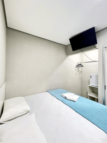 a bedroom with a bed with a tv on the wall at Morada do Lago in Palmas