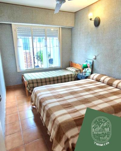 Una habitación de hotel con dos camas y una ventana. en Casa ideal familias-8 personas a 3 cuadras del mar, en Monte Hermoso