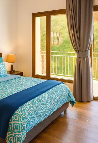 a bedroom with a bed and a large window at Chalet Asmoun in Imouzzer du Kandar