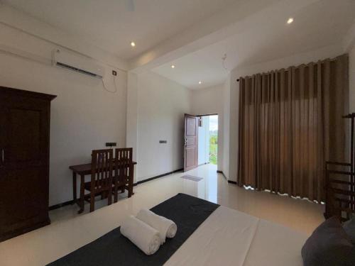 ein Schlafzimmer mit einem Bett und einem Schreibtisch darin in der Unterkunft Asai surf inn Arugambay in Arugam Bay