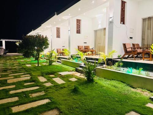 ein Innenhof mit Rasen und Stühlen in der Unterkunft Asai surf inn Arugambay in Arugam Bay