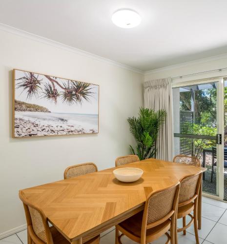 a dining room with a wooden table and chairs at Ivory Palms Resort Noosa in Noosaville