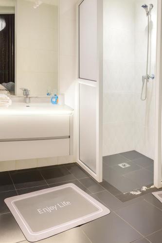 a white bathroom with a sink and a shower at Chalet Asmoun in Imouzzer du Kandar