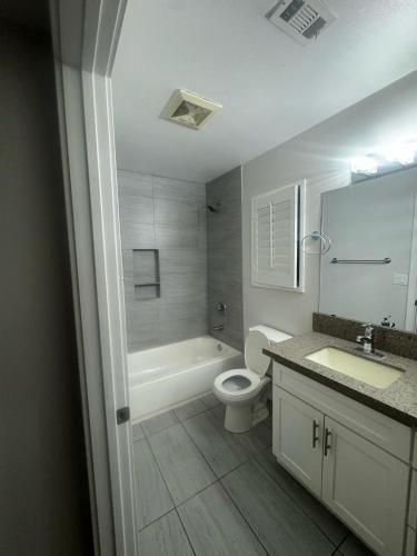 a bathroom with a toilet and a tub and a sink at Soulistic Vibes Normandie in Los Angeles