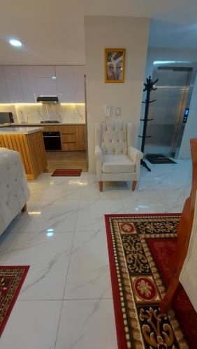 una sala de estar con un sofá y una silla en Luxury apartment, en Trujillo