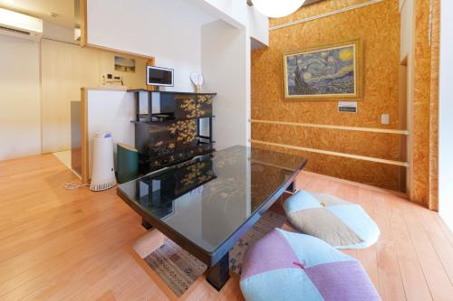 a glass table in the middle of a living room at Guesthouse Tonton Nobu in Kyoto