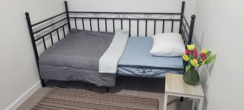 a bed in a room with a vase of flowers at Single Court in Abbotsford