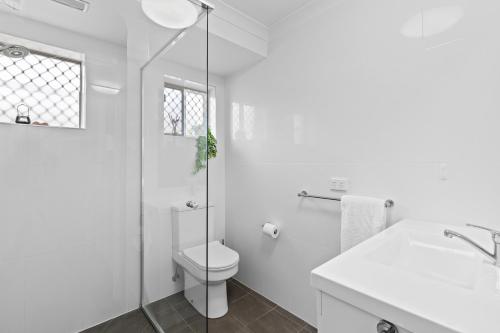 Un baño blanco con inodoro y ducha. en Central, Comfortable, Convenient - CCC, en Pialba