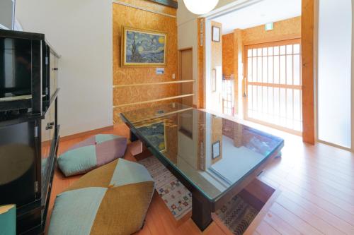 a living room with a glass table and a couch at Guesthouse Tonton Nobu in Kyoto