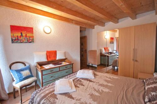 een slaapkamer met een bed, een bureau en een stoel bij In Cima alla Contrada in Pieve di Cadore