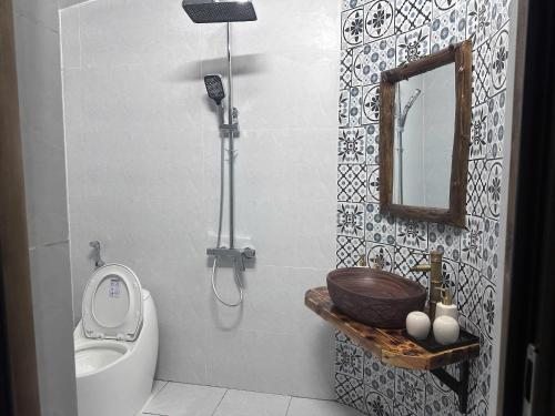 a bathroom with a toilet and a sink and a mirror at Wood Haven Homestay in Ninh Binh