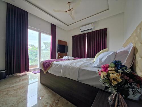 Un dormitorio con una cama grande con flores. en Broadway Inn, en Mysore