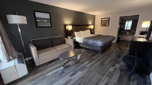 a hotel room with a bed and a couch at Wilkes-Barre Inn & Suites in Wilkes-Barre