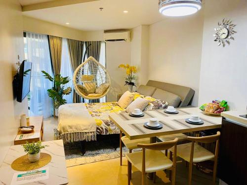 a room with a dining table and a living room at 1 Bedroom Suite at Tambuli Seaside Resort -Cebu in Maribago