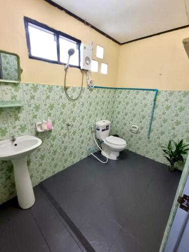 a bathroom with a toilet and a sink and a shower at June Guest House 1 in Thong Sala