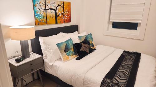 a bedroom with a bed with white sheets and pillows at New Langford Suite near Lake & Mall, Free Parking in Goldstream Station