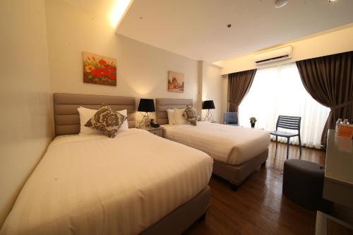 um quarto de hotel com duas camas e uma janela em Via Appia Tagaytay em Tagaytay