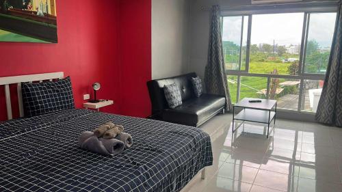 a teddy bear laying on a bed in a bedroom at KARON STUDIO APARTMENT in Karon Beach