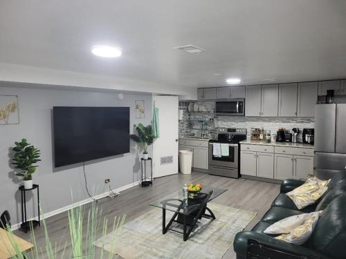 a living room with a couch and a tv and a kitchen at Garden Apartment Near Northwestern in Evanston