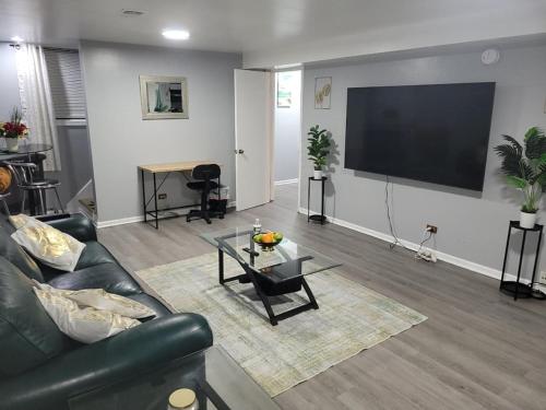 a living room with a couch and a flat screen tv at Garden Apartment Near Northwestern in Evanston