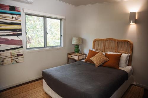 a bedroom with a bed and a window at Allure Stradbroke Resort in Point Lookout