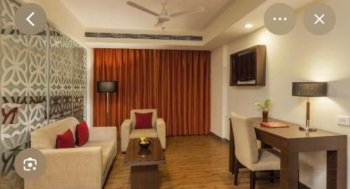 a living room with a couch and a desk in a room at Hotel Red Plaza -Near Delhi Airport & Free Airport Drop in New Delhi