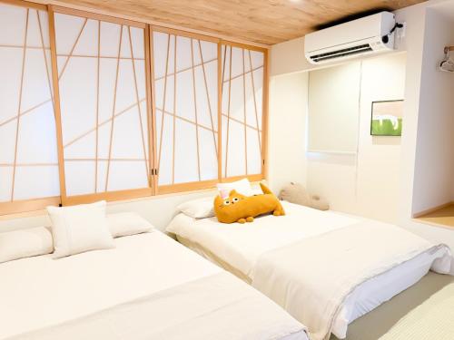 two beds in a room with two windows at Ōimazato-Japanese Garden Japanese Entire House with T a t ami Rooms for 8 & 5 Minutes Walk to Imazato &2 Baths 2 Toilets &Direct to Namba and Nipponbashi in Osaka