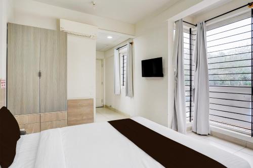 a bedroom with a large bed and a window at Super Hotel O KSR Bengaluru City Junction Formerly Gurudev Residency in Bengaluru