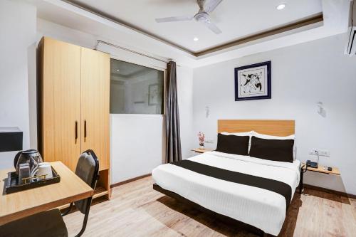 新德里Super Townhouse Yashobhoomi Formerly Hotel Grand Tashree的一张床铺、一张桌子和一张床